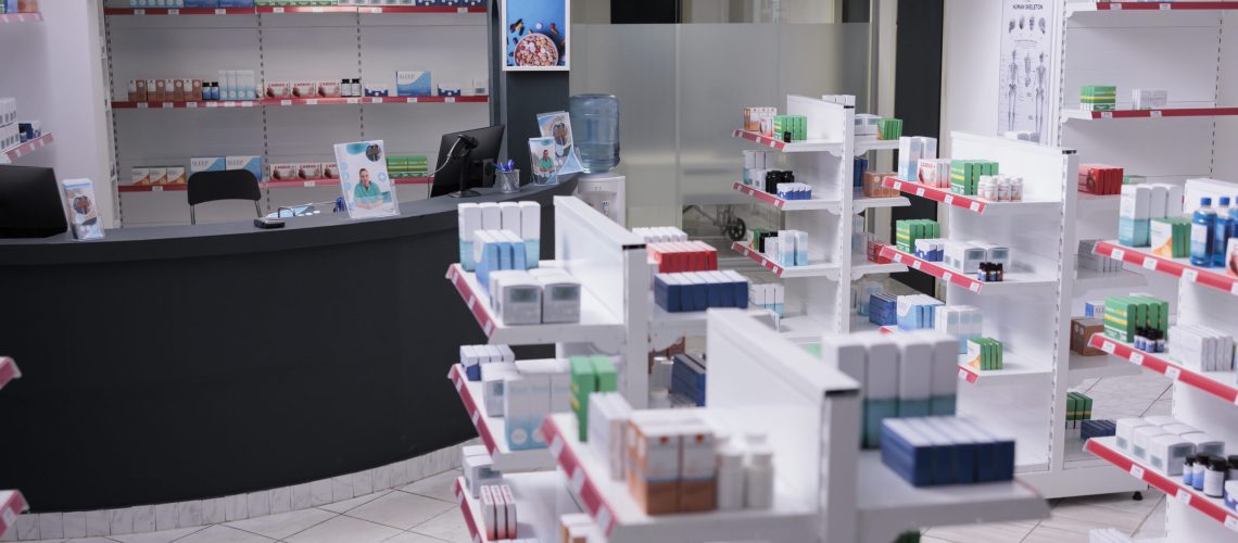 Bright empty drugstore equipped shelves full of supplements, pills, vitamin package. Drugstore with nobody in it ready for opening to customer. Health care products, medicine service support